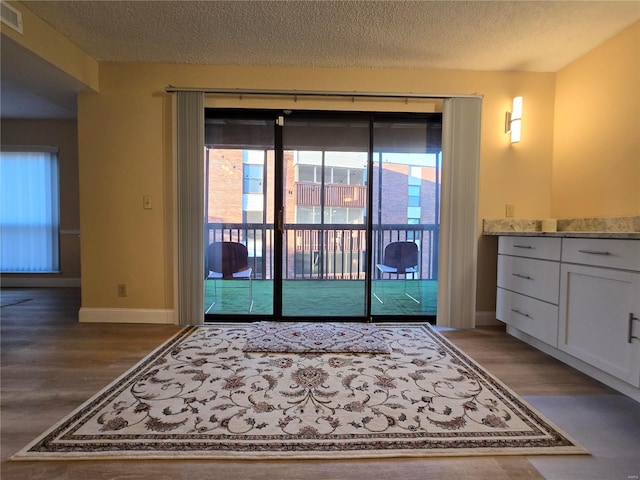 doorway to outside featuring hardwood / wood-style flooring and a textured ceiling