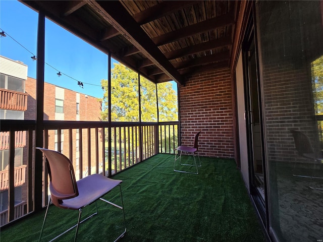 unfurnished sunroom featuring beamed ceiling