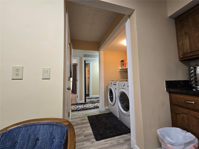 washroom featuring independent washer and dryer, a textured ceiling, and light hardwood / wood-style flooring