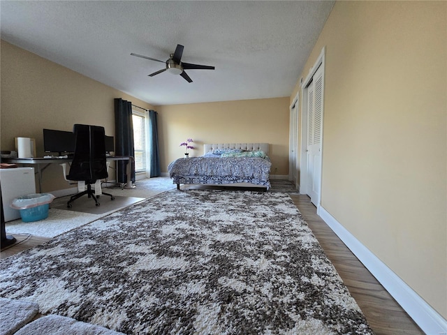 bedroom with a textured ceiling, wood-type flooring, a closet, and ceiling fan