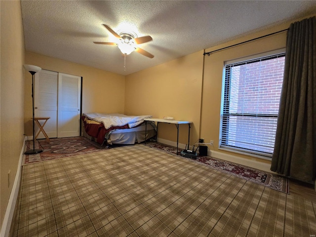 bedroom with a closet, a textured ceiling, and ceiling fan