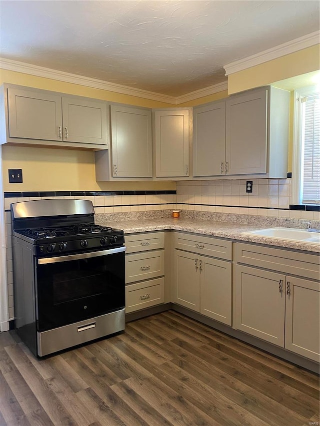 kitchen with dark hardwood / wood-style flooring, stainless steel range with gas cooktop, and ornamental molding