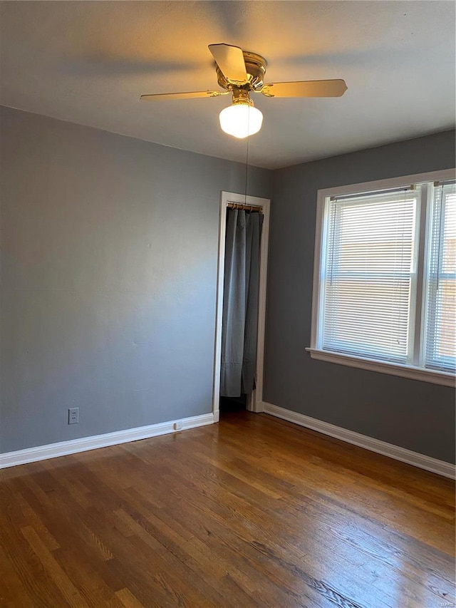 unfurnished room with dark hardwood / wood-style floors and ceiling fan