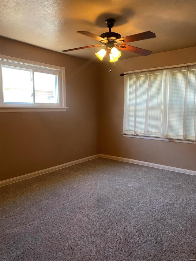 carpeted spare room with ceiling fan and a textured ceiling