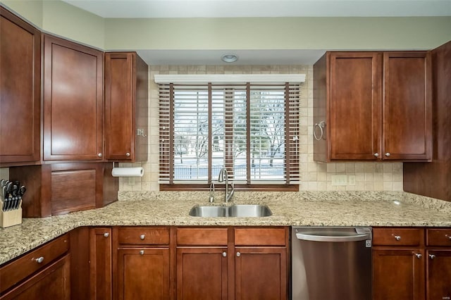 kitchen featuring backsplash, light stone countertops, sink, and stainless steel dishwasher