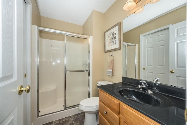 bathroom featuring tile patterned floors, vanity, toilet, and an enclosed shower