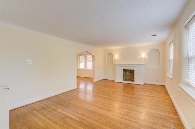 unfurnished living room with light hardwood / wood-style floors and a textured ceiling