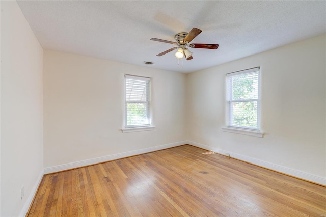 unfurnished room featuring ceiling fan, plenty of natural light, a textured ceiling, and light hardwood / wood-style flooring