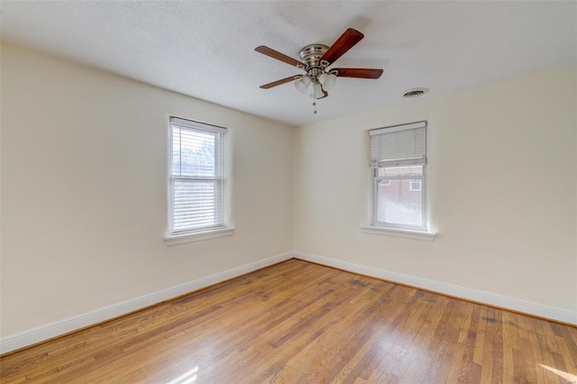 unfurnished room with ceiling fan, light hardwood / wood-style flooring, and a textured ceiling