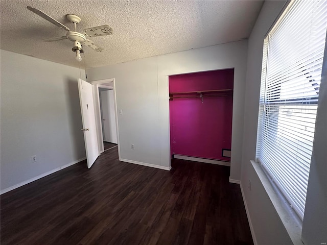 unfurnished bedroom with a textured ceiling, dark hardwood / wood-style flooring, a closet, ceiling fan, and baseboard heating