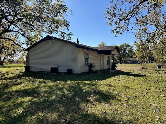 view of home's exterior featuring cooling unit and a yard