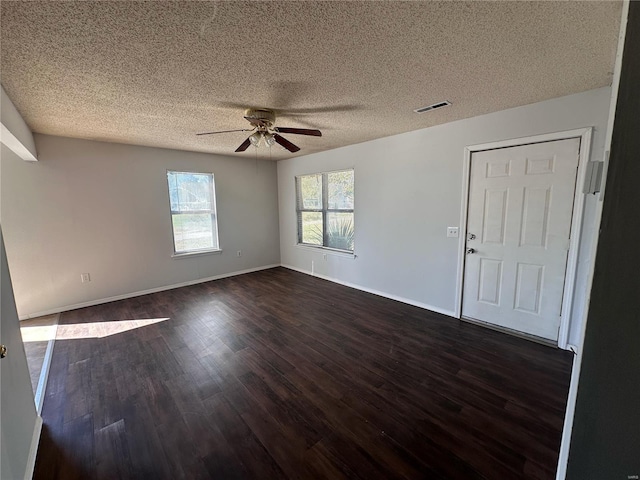 spare room with dark wood-type flooring, a textured ceiling, and ceiling fan