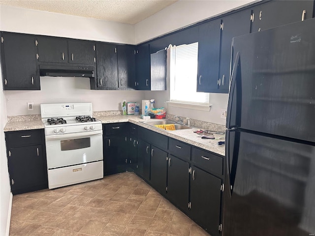 kitchen featuring a textured ceiling, sink, white gas range oven, and black fridge