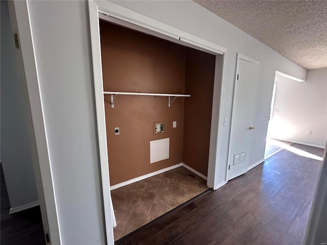 clothes washing area with electric dryer hookup, washer hookup, dark hardwood / wood-style flooring, and a textured ceiling