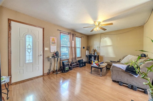 entryway with a textured ceiling, light wood-type flooring, and ceiling fan