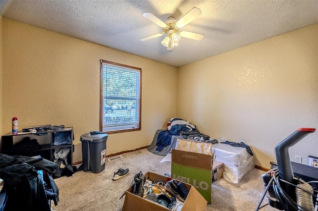 interior space featuring ceiling fan, carpet, and a textured ceiling