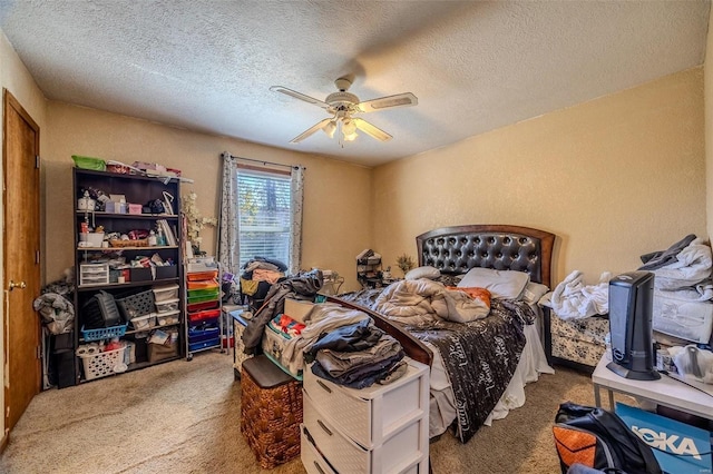 carpeted bedroom featuring ceiling fan and a textured ceiling