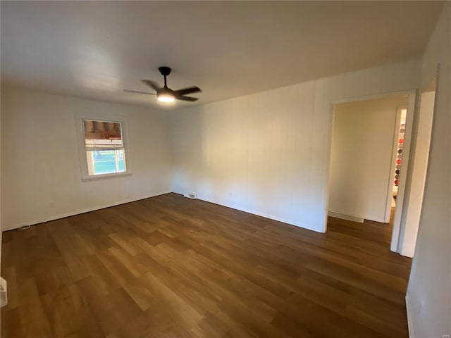 unfurnished room with ceiling fan and dark hardwood / wood-style flooring