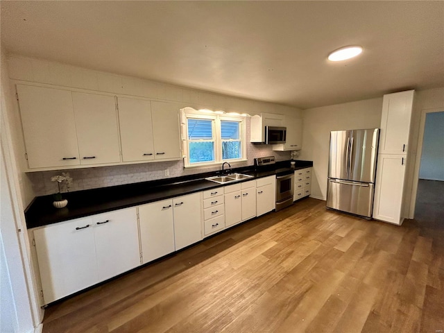 kitchen with white cabinetry, stainless steel appliances, and sink