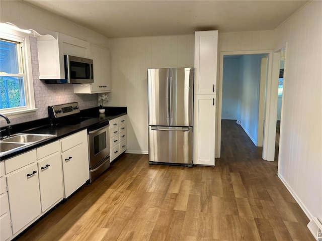 kitchen featuring sink, appliances with stainless steel finishes, light wood-type flooring, and white cabinets