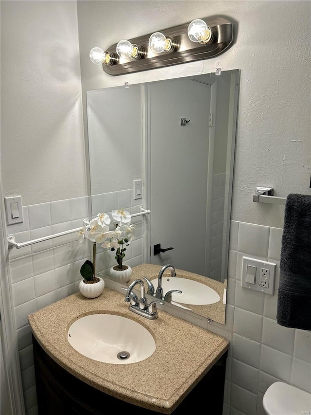 bathroom featuring vanity, toilet, and tile walls