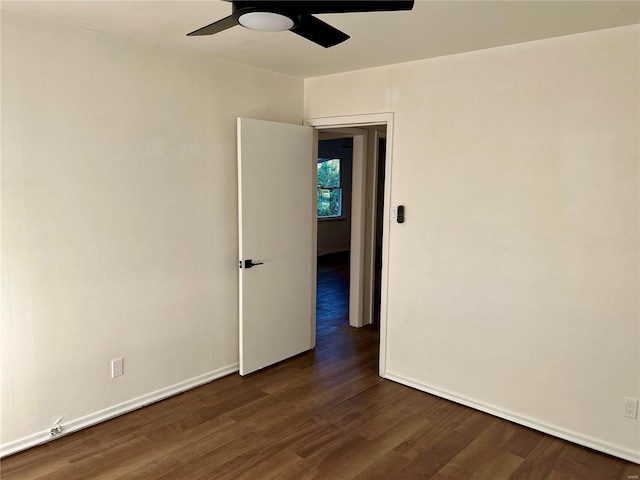 empty room with dark wood-type flooring and ceiling fan