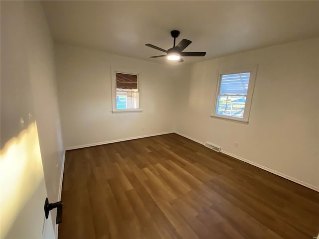 spare room with ceiling fan and dark hardwood / wood-style floors