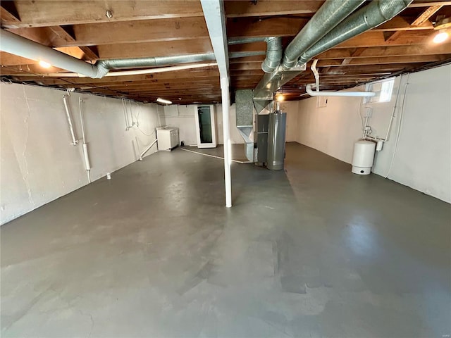 basement with water heater and separate washer and dryer