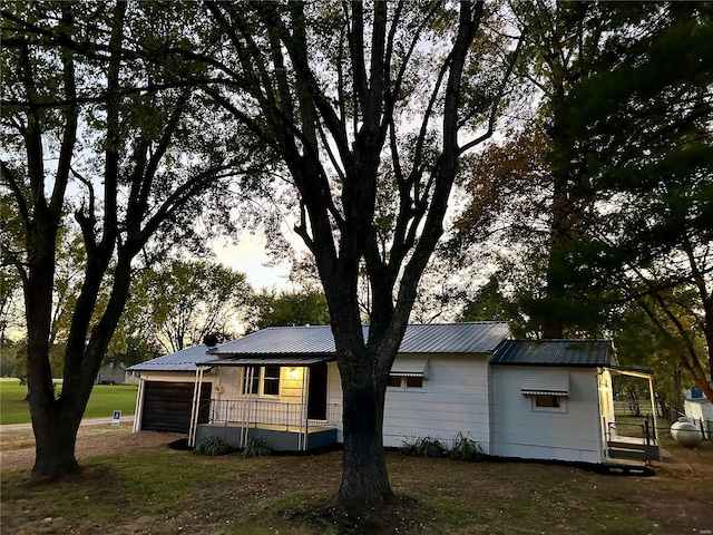 view of side of property with a porch and a lawn