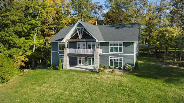 rear view of property with a balcony, a yard, and a patio