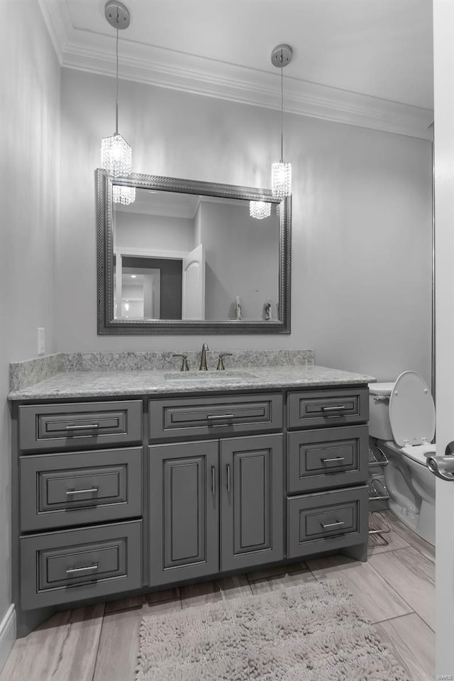 bathroom with vanity, crown molding, and toilet