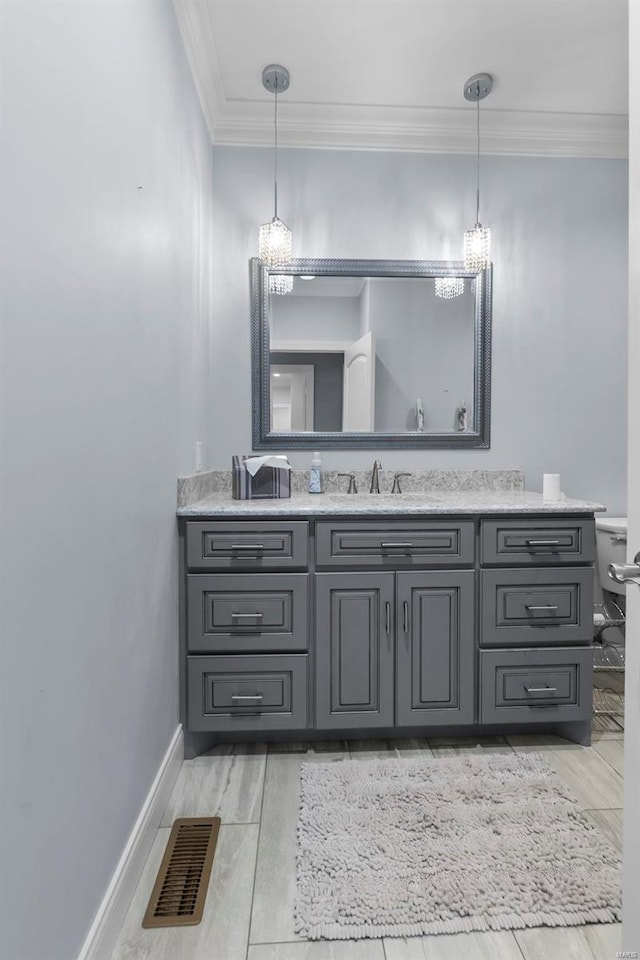 bathroom with vanity, hardwood / wood-style floors, crown molding, and toilet