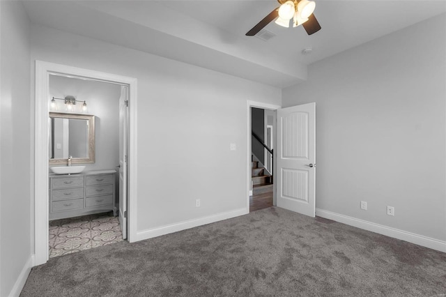 unfurnished bedroom featuring sink, ensuite bathroom, carpet floors, and ceiling fan