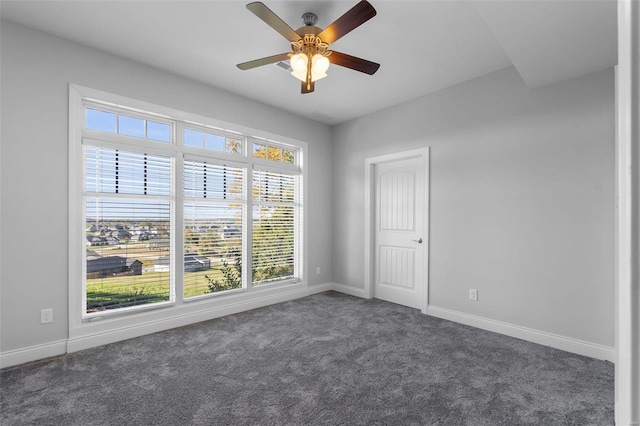 spare room with plenty of natural light and dark colored carpet