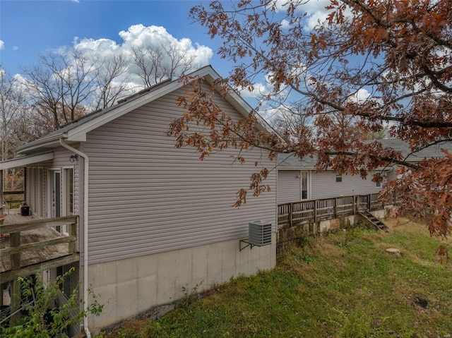 view of side of home featuring a wooden deck and central AC unit