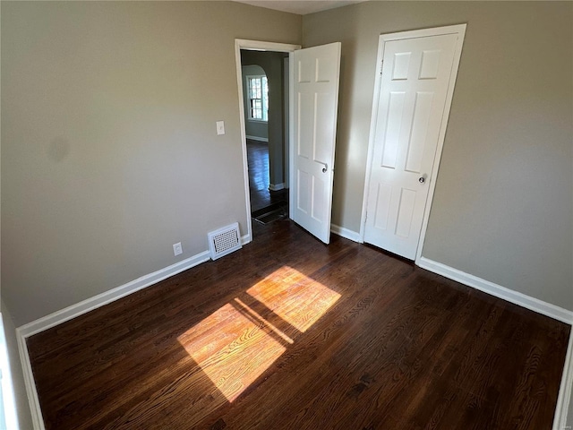 unfurnished bedroom with dark hardwood / wood-style flooring