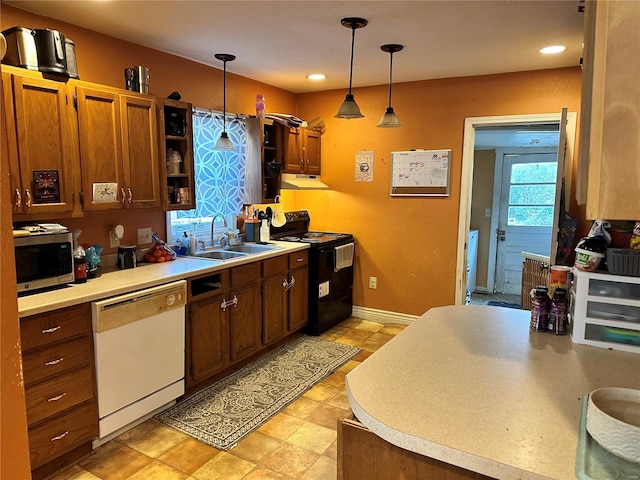 kitchen featuring electric range, sink, white dishwasher, and decorative light fixtures