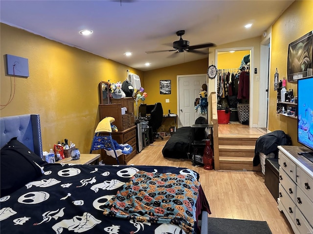 bedroom with vaulted ceiling, ceiling fan, a spacious closet, light hardwood / wood-style floors, and a closet