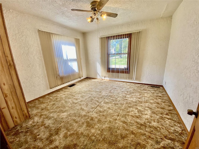 spare room featuring carpet, a textured ceiling, and ceiling fan