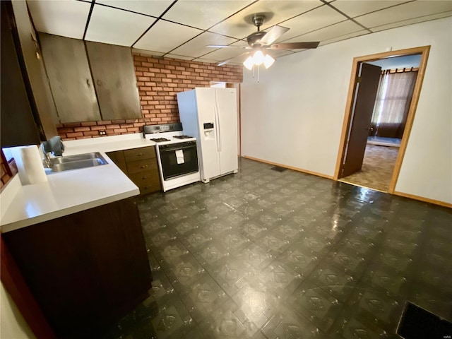 kitchen featuring dark brown cabinets, sink, a paneled ceiling, white appliances, and ceiling fan