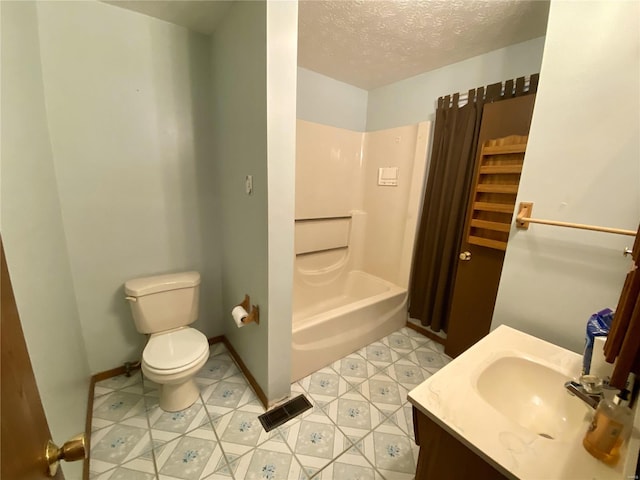 full bathroom with tile patterned floors, toilet, tub / shower combination, vanity, and a textured ceiling