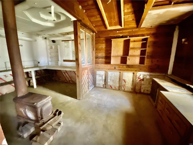 misc room featuring wooden walls and concrete floors