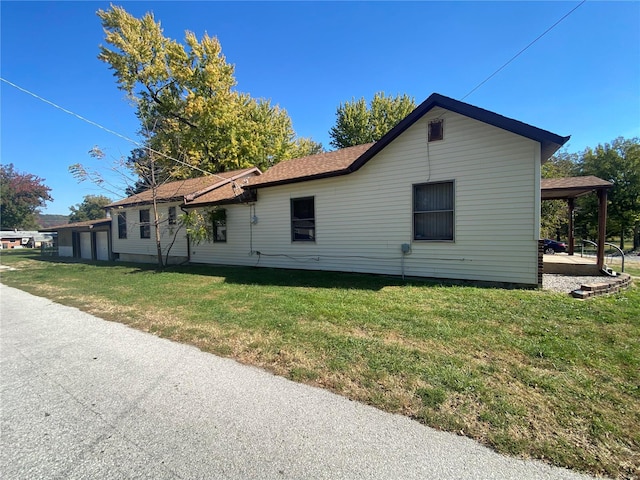 view of side of property featuring a lawn and a carport