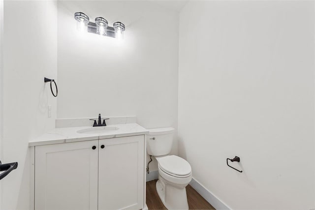 bathroom featuring toilet, hardwood / wood-style floors, and vanity