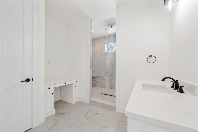 bathroom with a tile shower and vanity