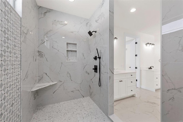 bathroom featuring tiled shower and vanity