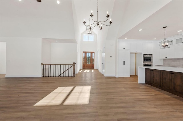 entrance foyer with a towering ceiling and light wood-type flooring