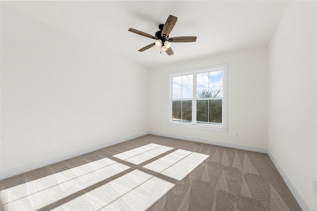 carpeted spare room with ceiling fan