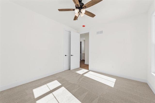 carpeted spare room with ceiling fan