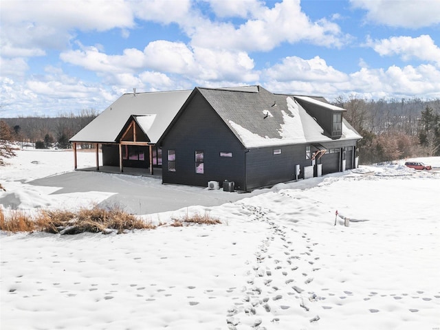 snow covered property featuring a garage